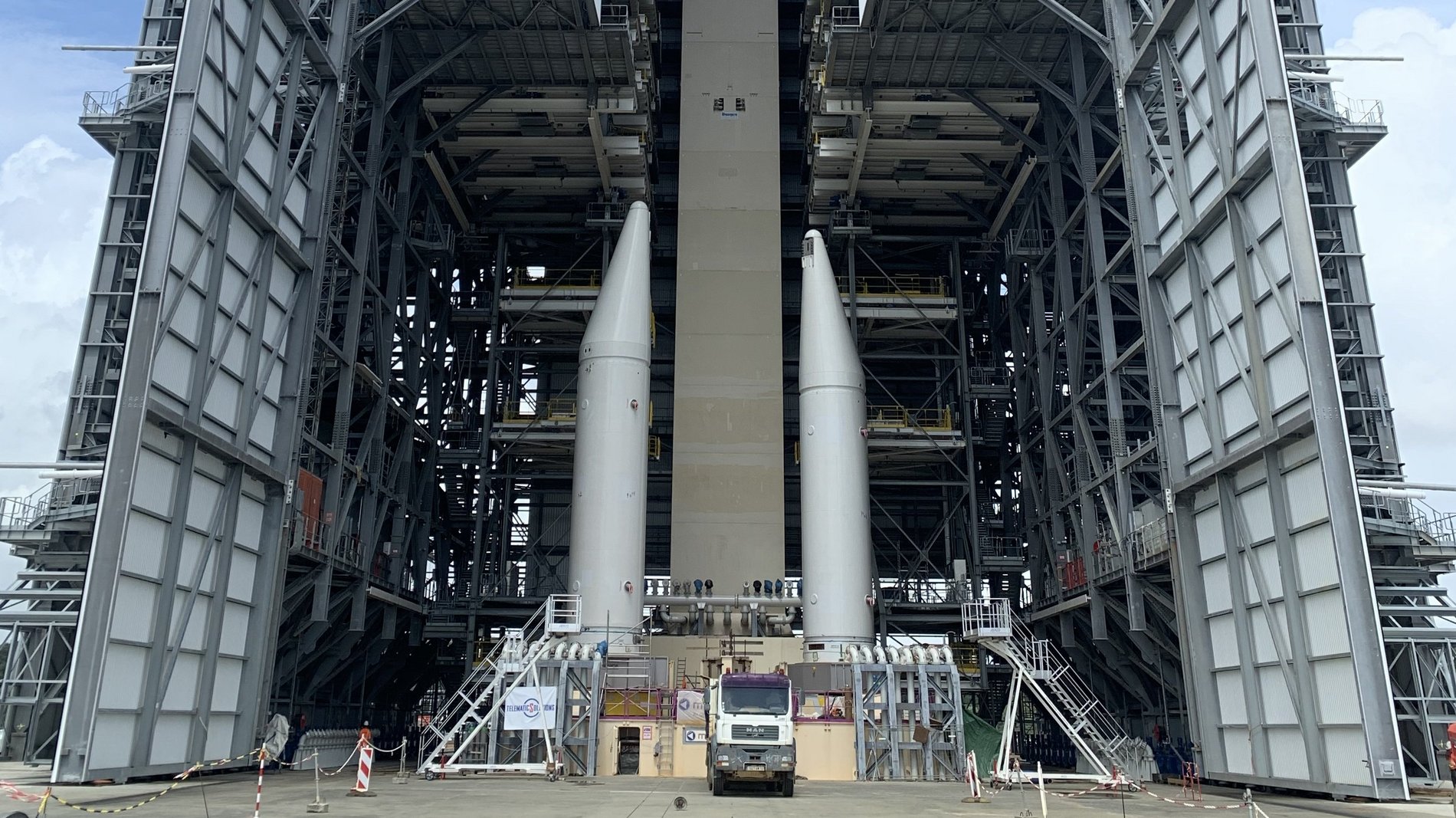 große geöffnete Montagehalle mit einer teilweise zusammengebauten Rakete