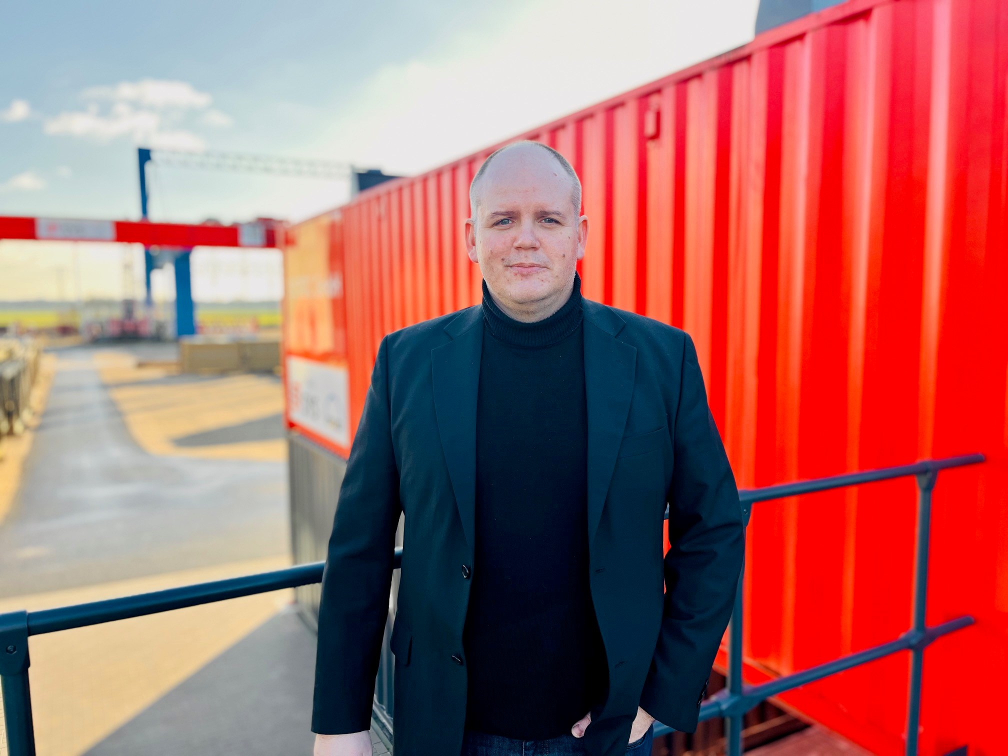 Herr François Gautier vor orangefarbenem Container